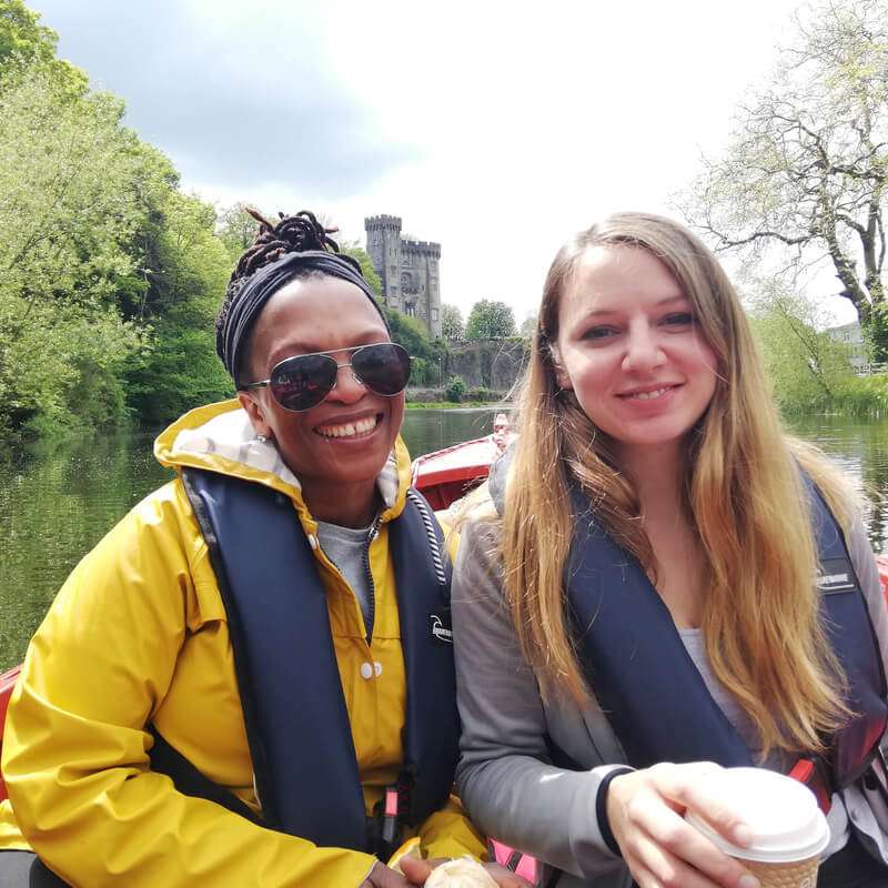 Two ladies on a boat in Kilkenny. Kilkenny castle in background.