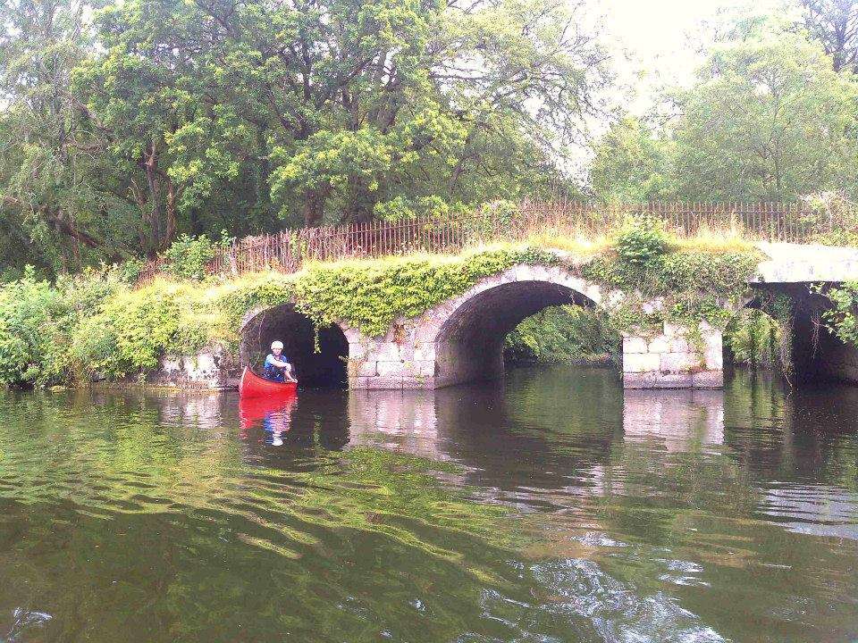 Canoer under bridge at mouth of Mountain River