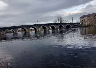 Bridge and malt stores on river Barrow in Goresbridge, Ireland on a grey day.