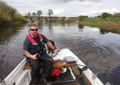 John Creaney driving a boat at Bert Bridge on the river Barrow
