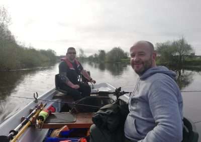 John Creaney and Mark Day from Athy fishing on a boat on the river Barrow in Ireland