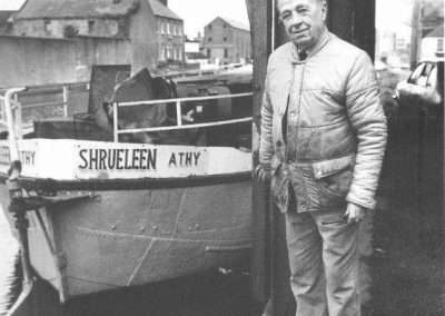Old man beside a boat named Shruleen