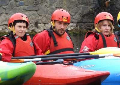 Three kayaking students together on river Nore