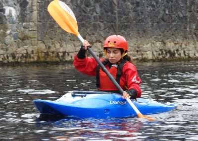 Lady in a Blue kayak learning to paddle
