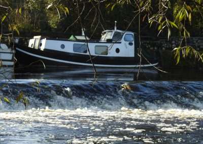 Boat moored above the weir on the river Barrow in Graiguenamanagh, county Kilkenny, Ireland
